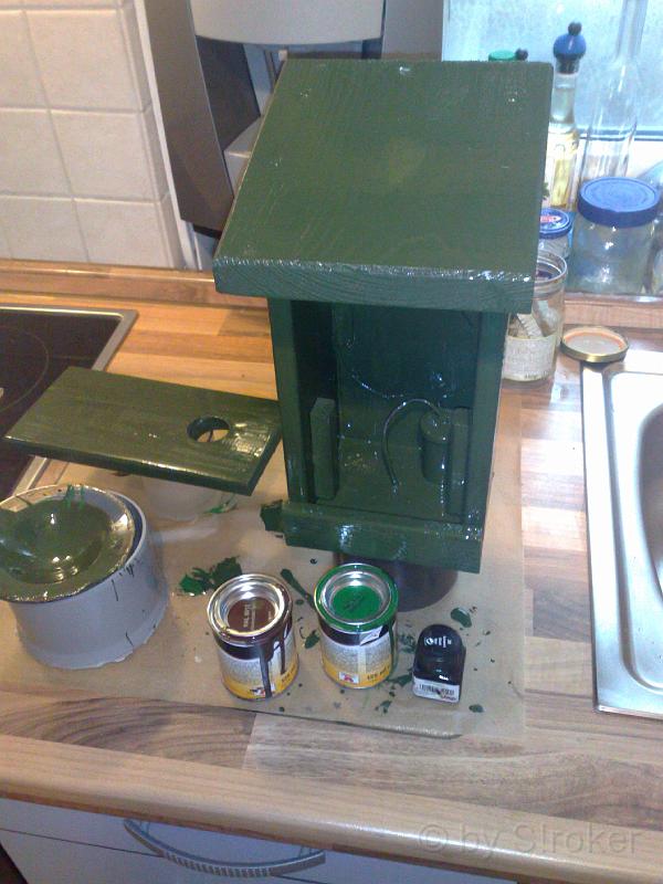 08.jpg - Hier ist der erste von insgesammt 5 Anstrichen.Es wurden insgesammt drei Farbtöne verwendet: (Grün, Braun und Schwarz.)Zunächste wurde einmal in Grün vorgestrichen, aber weil mir der Grünton zu auffällig war, habe ich noch einen eigenen ausGrün, Braun und Schwarz zusammen gemischt. zu guter letzt wurde das Vogelhaus mit einer Dose Matt-Schwarzangenebelt, ehe es drei schichten Klarlack bekam.